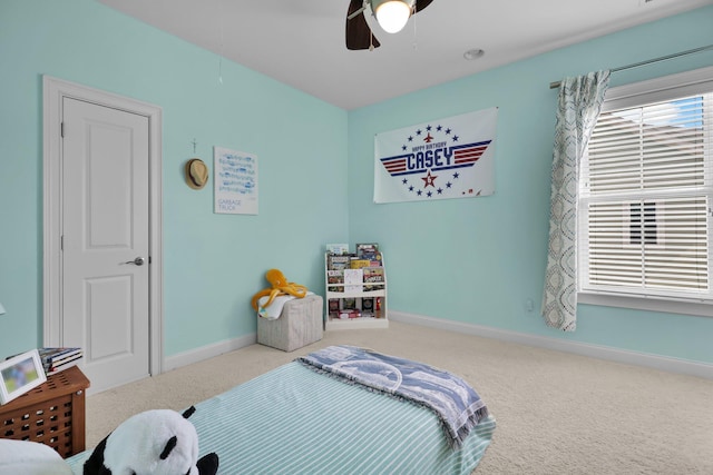 carpeted bedroom featuring a ceiling fan, attic access, and baseboards