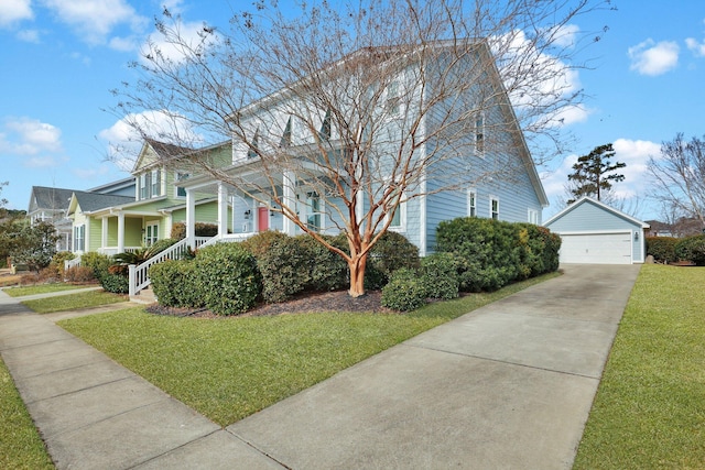 view of front of home with a garage, a front lawn, and an outbuilding