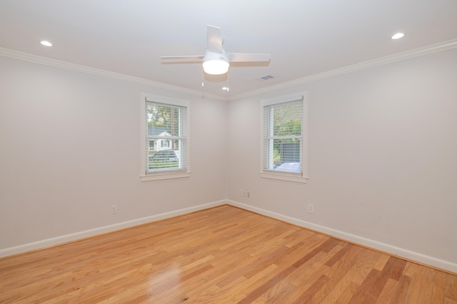 spare room with light hardwood / wood-style floors, a wealth of natural light, and ornamental molding