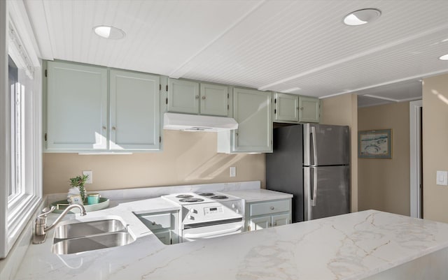 kitchen with light stone countertops, white appliances, and sink