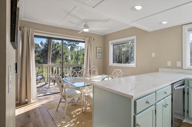 kitchen with ceiling fan, light stone counters, kitchen peninsula, and light hardwood / wood-style flooring