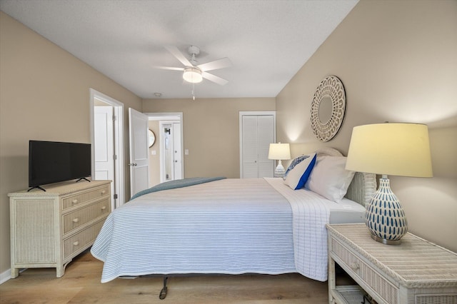 bedroom featuring a textured ceiling, a closet, ceiling fan, and light hardwood / wood-style floors