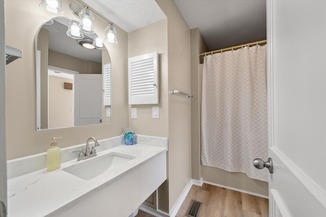 bathroom featuring vanity, a textured ceiling, and hardwood / wood-style flooring