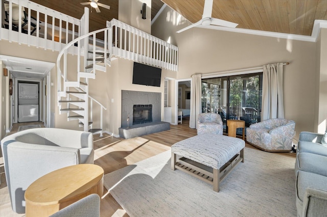 living room with a high end fireplace, high vaulted ceiling, ceiling fan, and wood ceiling