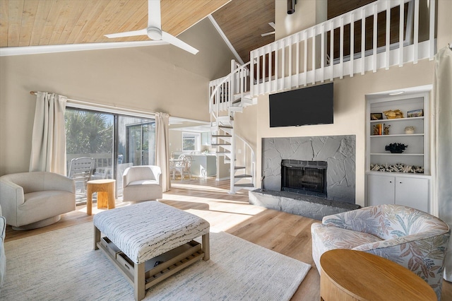 living room with wood-type flooring, a premium fireplace, high vaulted ceiling, and wood ceiling