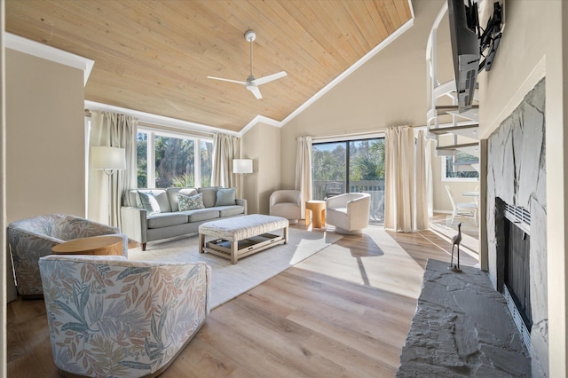 living room featuring high vaulted ceiling, a stone fireplace, ceiling fan, light wood-type flooring, and wood ceiling