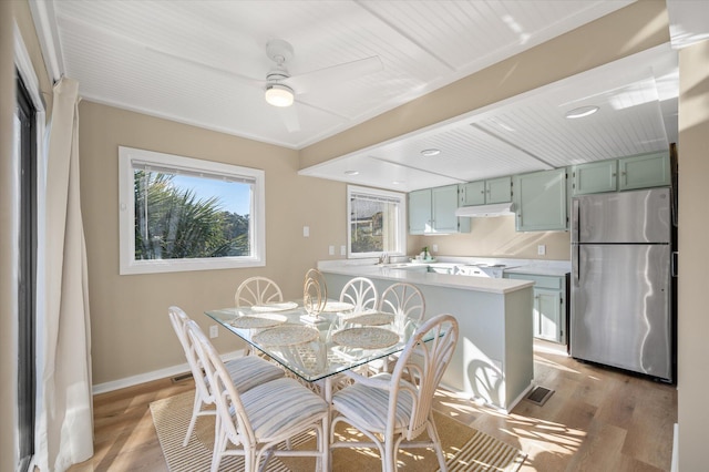 dining area featuring ceiling fan, light hardwood / wood-style floors, and sink