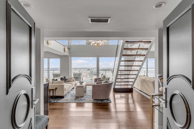 330 Concord St Unit 18F, Charleston, SC 29401 - living area with a notable chandelier, visible vents, a water view, wood finished floors, and stairway