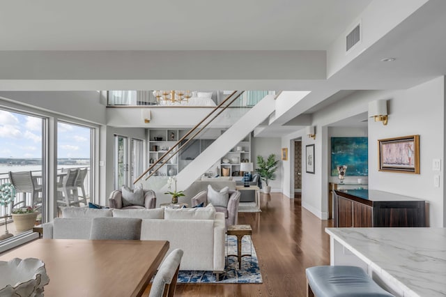 330 Concord St Unit 18F, Charleston, SC 29401 - living room featuring a notable chandelier, visible vents, baseboards, stairway, and dark wood-style floors