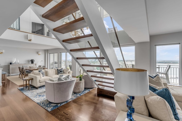 330 Concord St Unit 18F, Charleston, SC 29401 - living area featuring a water view, wood finished floors, a high ceiling, and stairs