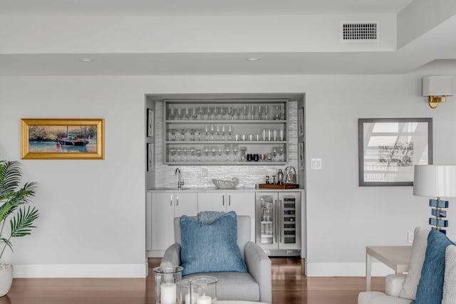 330 Concord St Unit 18F, Charleston, SC 29401 - living area featuring wood finished floors, wet bar, visible vents, beverage cooler, and baseboards