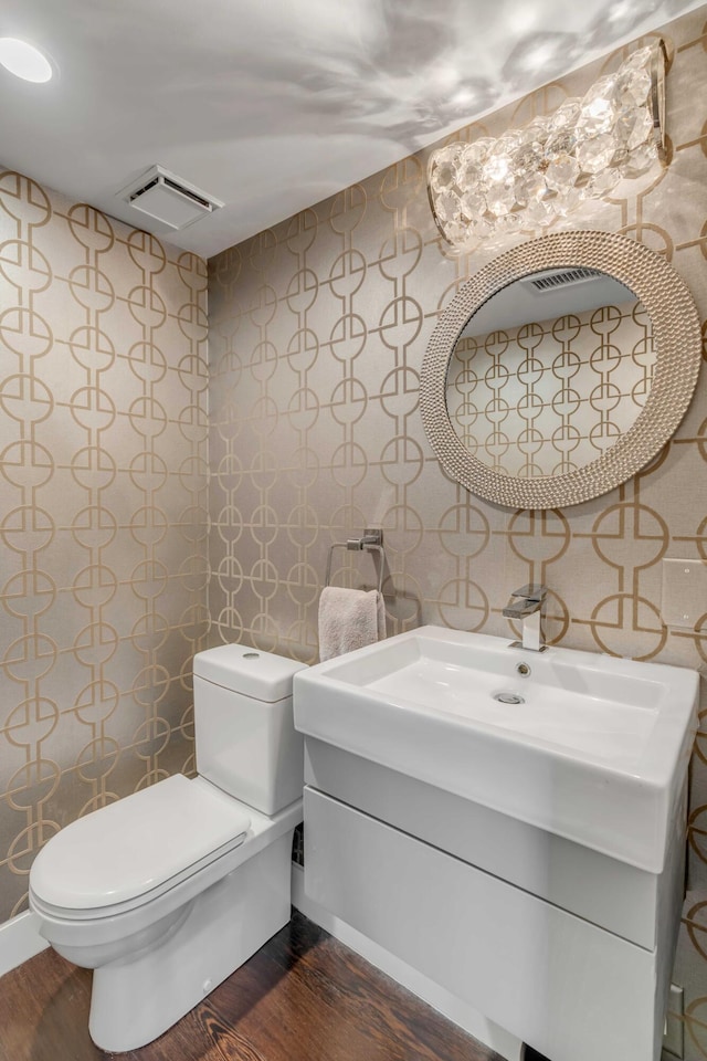 330 Concord St Unit 18F, Charleston, SC 29401 - half bathroom with toilet, visible vents, wood finished floors, and vanity