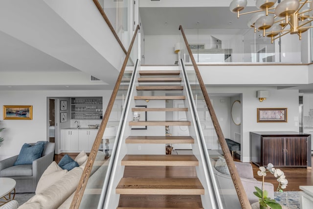 330 Concord St Unit 18F, Charleston, SC 29401 - staircase with indoor bar, wood finished floors, visible vents, an inviting chandelier, and a high ceiling