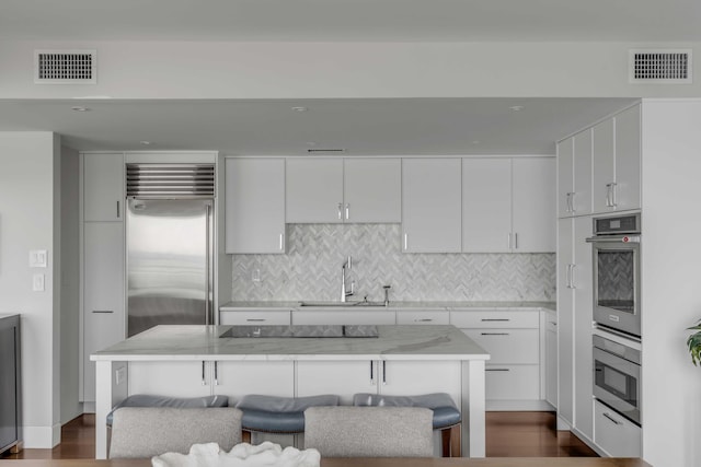 330 Concord St Unit 18F, Charleston, SC 29401 - kitchen featuring backsplash, appliances with stainless steel finishes, visible vents, and a sink