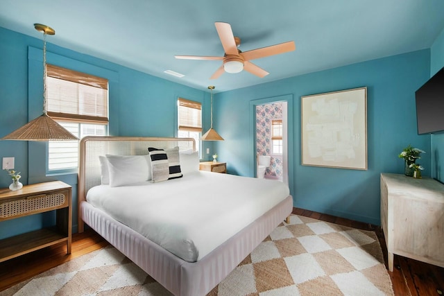 bedroom with light wood finished floors, baseboards, and a ceiling fan