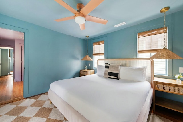 bedroom with a ceiling fan, multiple windows, and visible vents