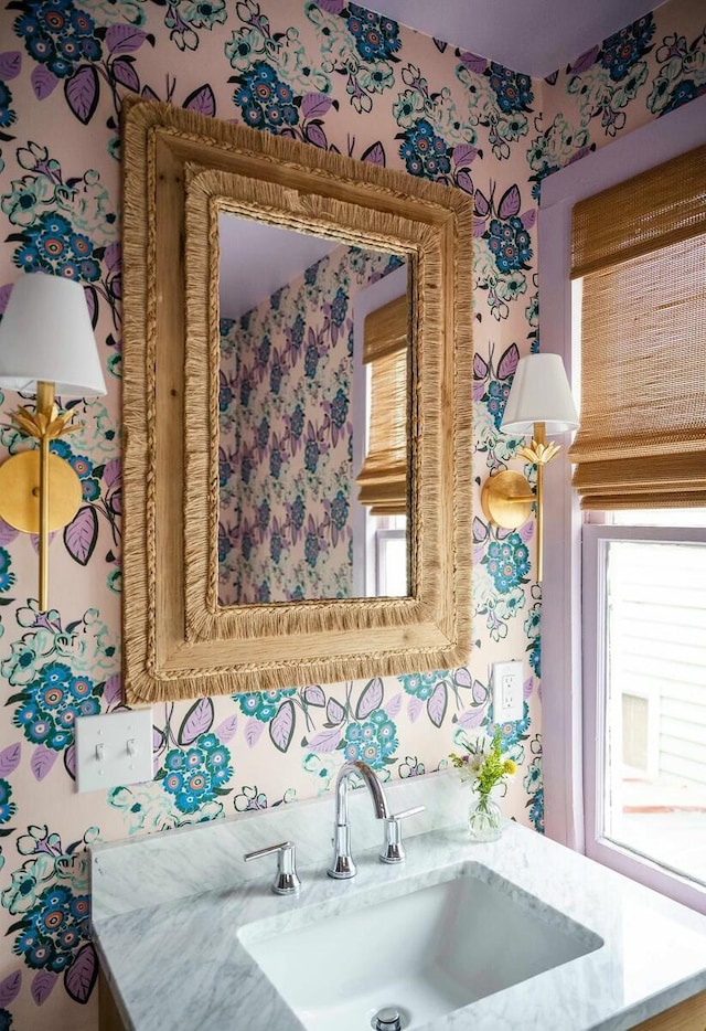 bathroom with vanity and wallpapered walls