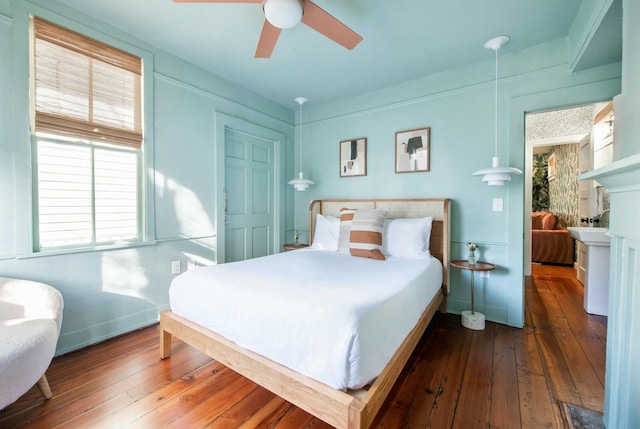 bedroom with dark wood-type flooring, baseboards, and a ceiling fan