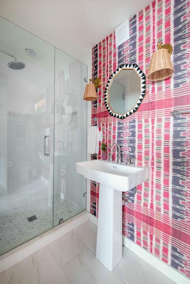 bathroom featuring marble finish floor and a shower stall