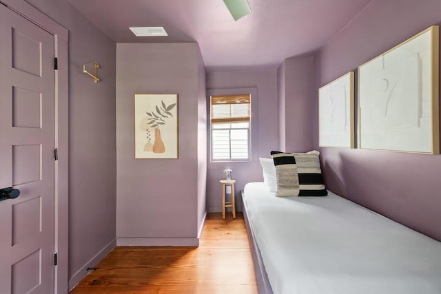 bedroom with baseboards, visible vents, and light wood-style floors