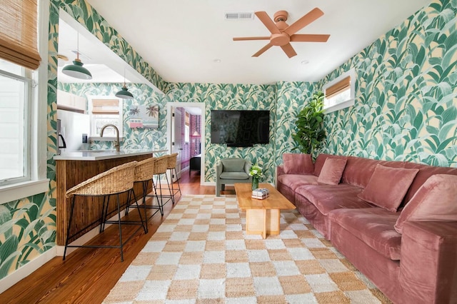 living room featuring light wood-style floors, baseboards, and wallpapered walls