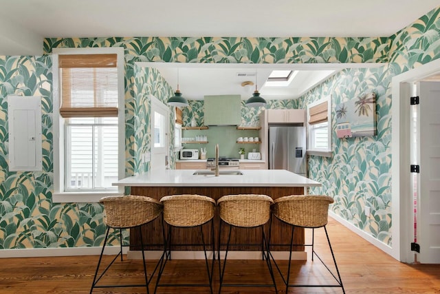 kitchen with wallpapered walls, electric panel, white microwave, stainless steel refrigerator with ice dispenser, and open shelves