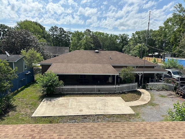 rear view of property with fence and a shingled roof