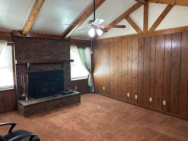 unfurnished living room featuring lofted ceiling with beams, ceiling fan, carpet, and wood walls