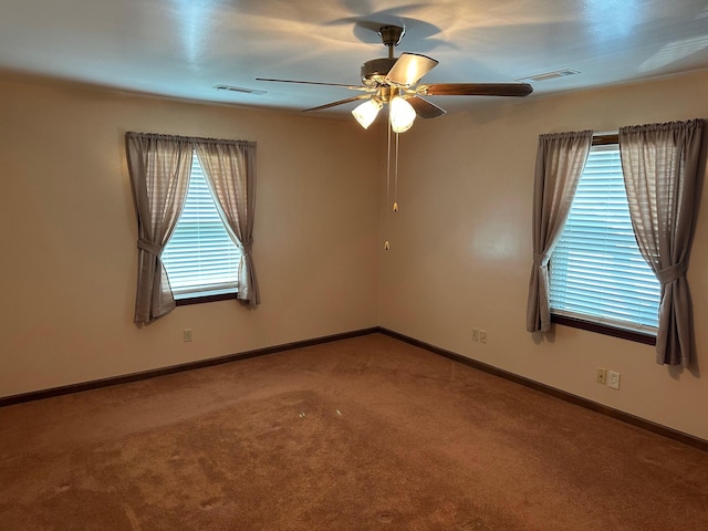 unfurnished room featuring ceiling fan, visible vents, baseboards, and carpet