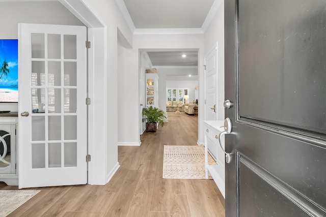 foyer entrance with light wood-type flooring and crown molding