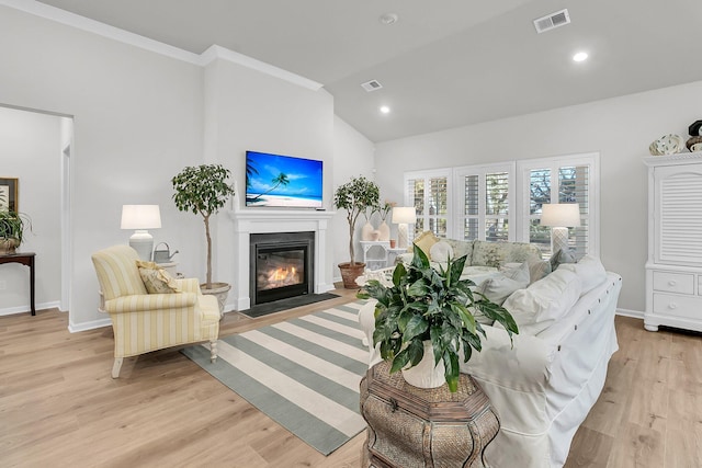 living room featuring light wood-type flooring, vaulted ceiling, and crown molding