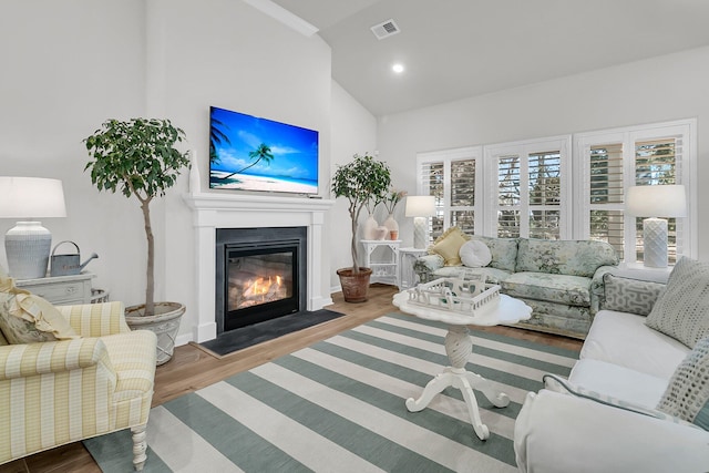 living room featuring lofted ceiling and hardwood / wood-style flooring