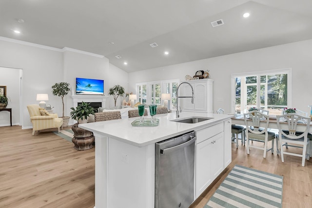 kitchen featuring dishwasher, white cabinetry, a kitchen island with sink, and sink