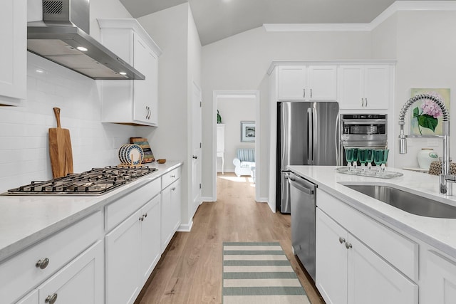 kitchen featuring white cabinetry, sink, wall chimney exhaust hood, and appliances with stainless steel finishes