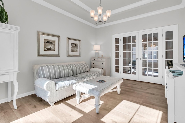 living room featuring french doors, a notable chandelier, and light wood-type flooring