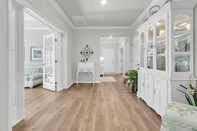 hall with light hardwood / wood-style floors and ornamental molding