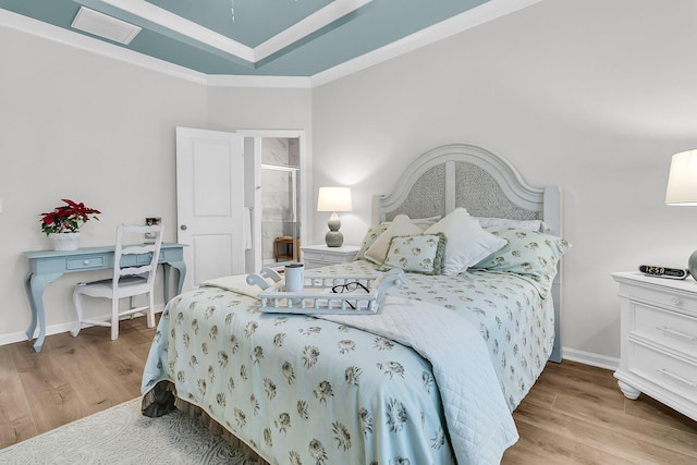 bedroom with a raised ceiling, light hardwood / wood-style floors, and ornamental molding