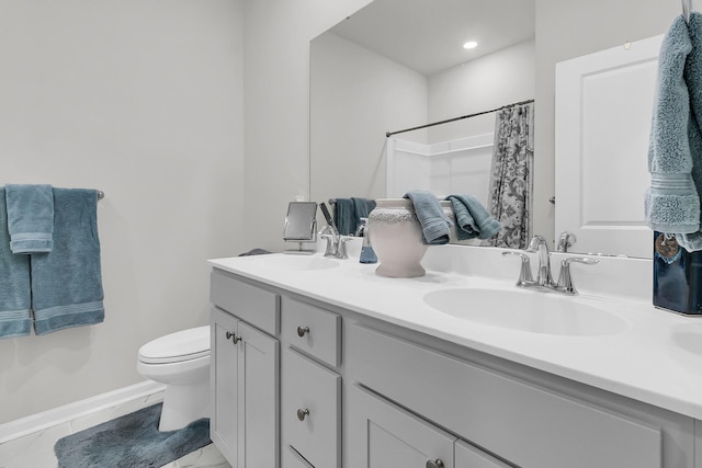 bathroom with curtained shower, vanity, and toilet