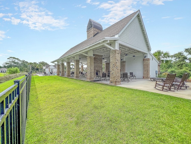 back of house with a yard and a patio