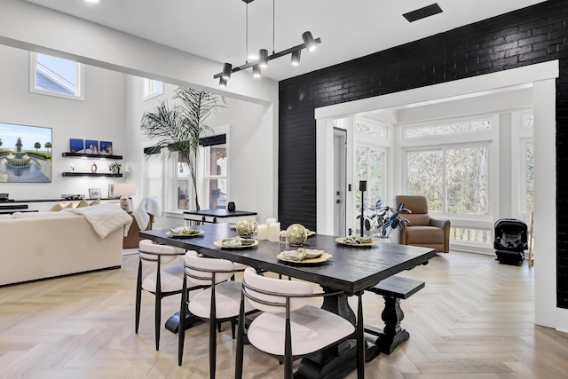 dining area with brick wall and a high ceiling