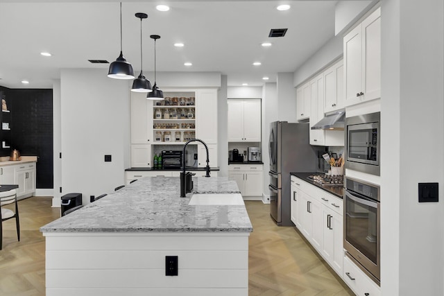 kitchen with open shelves, visible vents, appliances with stainless steel finishes, a sink, and under cabinet range hood