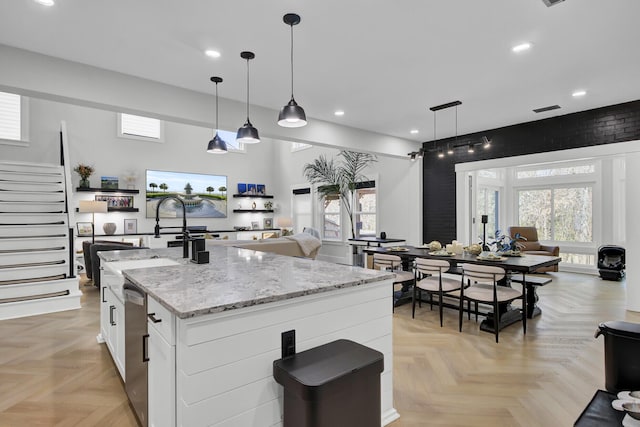 kitchen featuring open floor plan, plenty of natural light, and white cabinetry