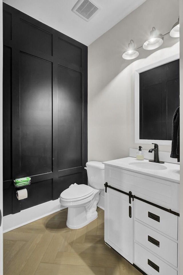 bathroom with visible vents, vanity, and toilet