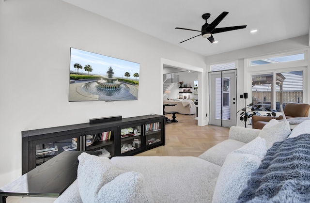 living area with ceiling fan, a glass covered fireplace, and recessed lighting