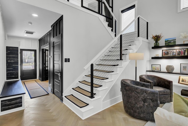 staircase featuring baseboards, visible vents, and recessed lighting