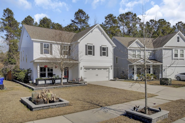 traditional-style house with a shingled roof, driveway, and an attached garage