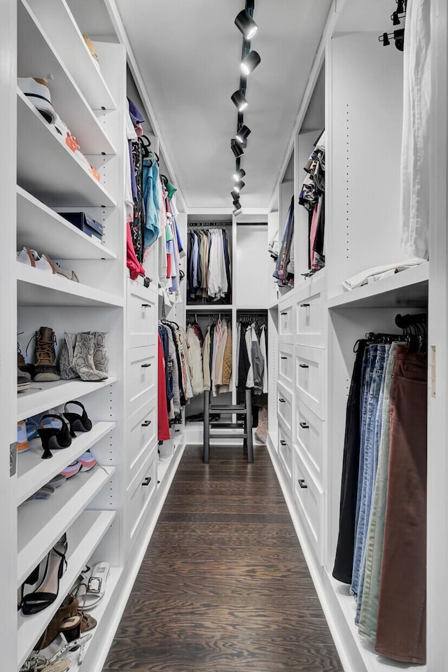 walk in closet with dark wood-style floors