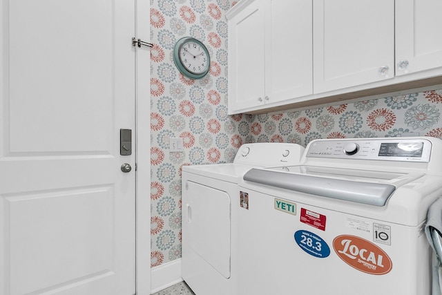 laundry area featuring wallpapered walls, cabinet space, washing machine and clothes dryer, and baseboards