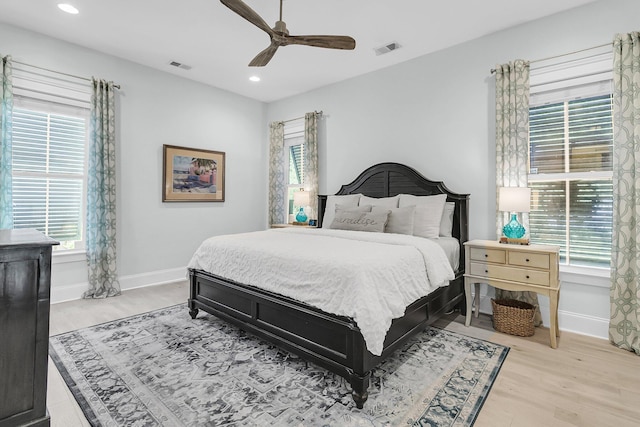 bedroom with multiple windows, baseboards, light wood-style flooring, and recessed lighting