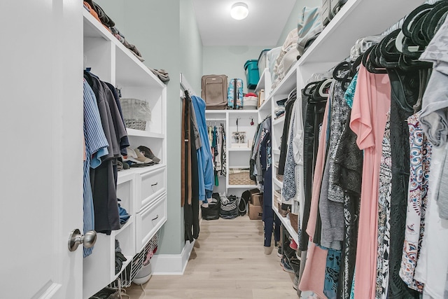 walk in closet with wood finished floors